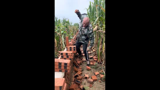Man demonstrates brick-breaking strength in a cornfield in Liaoning, China