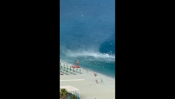 Waterspout reaches the beach and sends umbrellas flying in Scilla, Calabria, Italy
