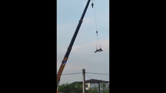 Crane operator lifts drunk man on pallet swing in Solovei-Kliuch, Primorye, Russia