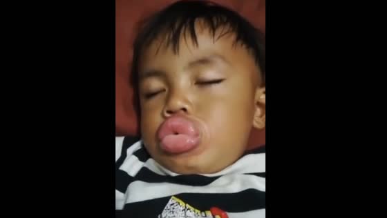Sleeping nephew holds bottle cap in funny moment in Bogor, Indonesia