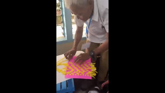 70-year-old man joins young students in classroom weaving activity in Leyte, Philippines