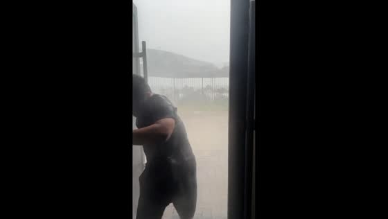 Man struggles to close door against fierce winds in Shaanxi, China