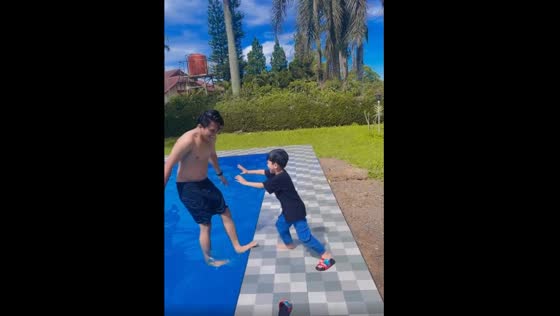 The cute child tried to push his father into the pool, then he fell as well!