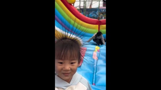 Kid’s hair stands up from static electricity after sliding on inflatable in Anhui, China