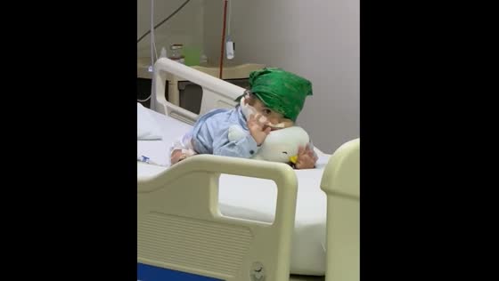 Child waves from hospital bed in Bogota