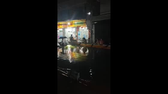 Dragon boat rowing through flooded street in Guangdong, China