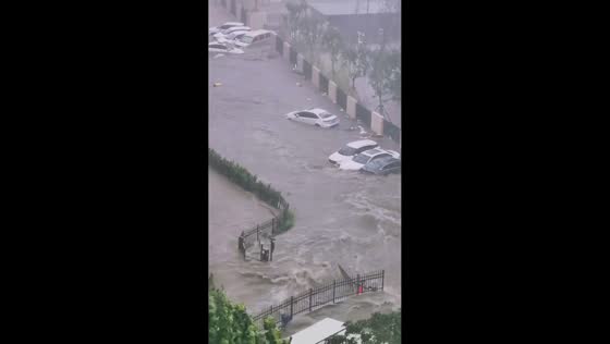 Floodwaters sweep across street and move vehicles in Shandong, China
