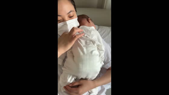 Nurse gently tickles infant in an adorable moment in Sichuan, China