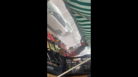 Strong winds and heavy rain batter market stall in Naples, Italy