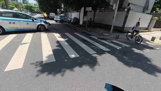 Delivery rider avoids serious injury in collision with U-turning e-taxi in Guangdong, China