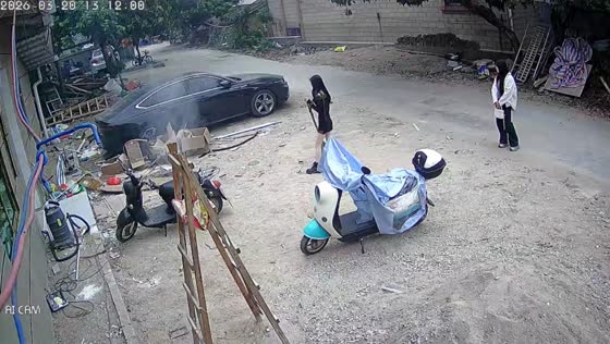 Smoking cardboard fire put out with sand by pedestrians in Guangdong, China
