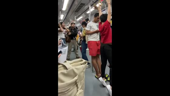 Passenger hangs awkwardly from high train handle in Manila, Philippines