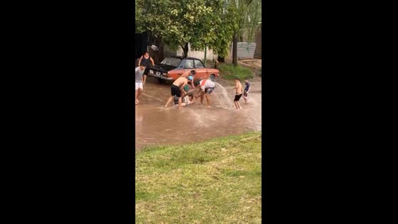Local residents play lighthearted prank in flood waters amidst storm aftermath