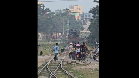 People on railway tracks as train approaches in Mymensingh, Bangladesh