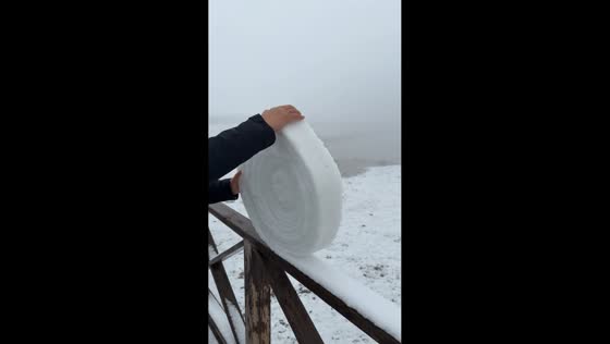 Rolling giant snow from wooden railing in Qinghai, China