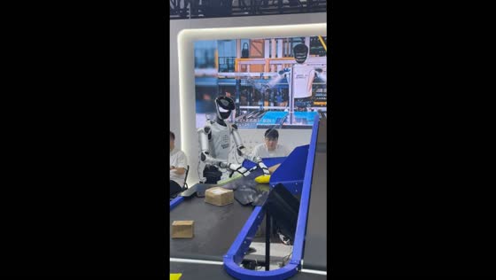 Robot sorts and flips packages on a moving conveyor belt in Beijing, China