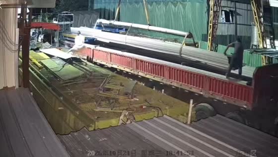 Woman loses balance while helping load metal pipes onto a truck in Zhejiang, China