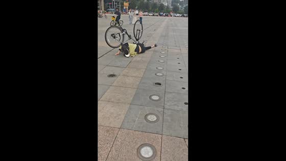 Woman falls after bicycle wheel gets stuck in ground gap in Chongqing, China