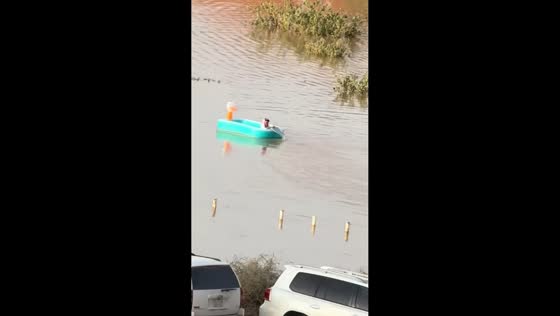 Man paddles kiddie pool through floodwater in Al-Muzahmiya, Riyadh, Saudi Arabia