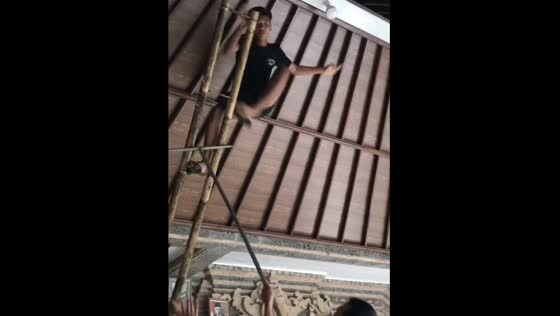 Close call: friends catches falling friend while changing lights in Bali