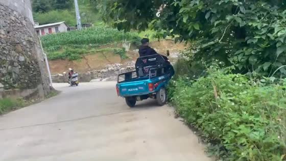 Tricycle rider crashes after looking back on downhill road in Yunnan, China