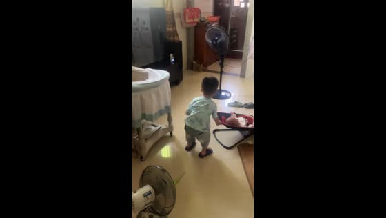 Little brother gently rocks siblings to keep them calm in Guangdong, China