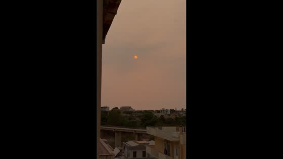 Striking red-orange sun glows through Saharan dust over Sciacca, Italy