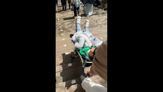Boy in stroller bounces down park steps in Jiuzhaigou, China