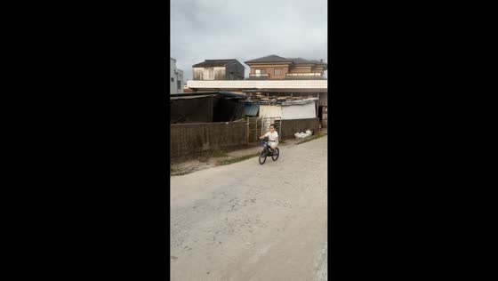 Boy falls after making a peace sign while riding a bicycle in Guangdong, China