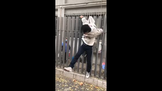 Man gets stuck while climbing a metal fence in Beijing, China