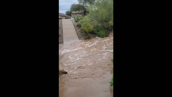 Heavy rain sends floodwaters rushing through a desert wash in Scottsdale, USA