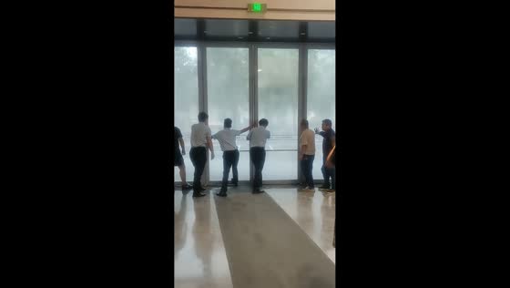 Employees brace glass doors as powerful storm hits in Xi'an, China