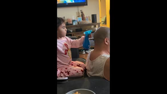 Daughter combs dad’s bald head in Los Angeles, USA