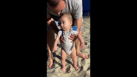 Baby’s first steps in the sand in Myrtle Beach, South Carolina, USA