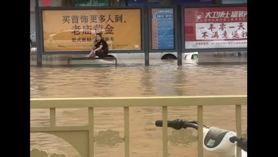 Man stays on phone during flood in Henan, China