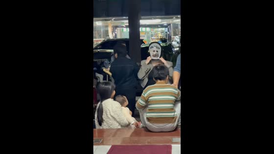 Woman playfully startles child with mask in China