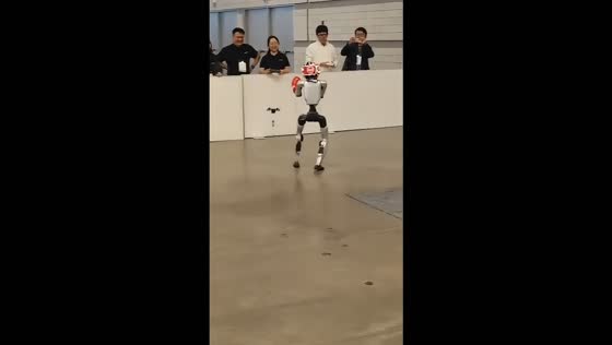 Humanoid robot kicks a small drone during a robotics demonstration in Hangzhou, China