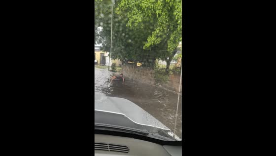 Driver splashes man floating in flood in Maracay, Venezuela