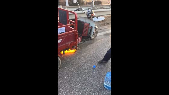 Driver assists deaf-mute man in putting out burning tricycle in Shandong, China