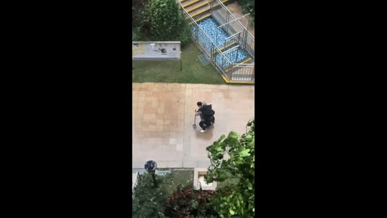 Cleaning lady helps elderly man during storm in Guangdong, China