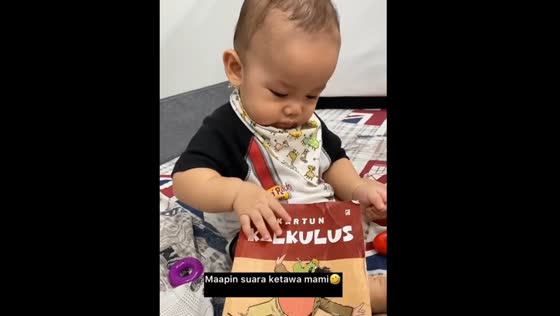 Baby prefers books over phone in Karawaci, Indonesia