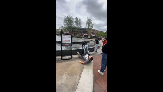Man slips near fountain and gets helped by crowd in Kansas, USA