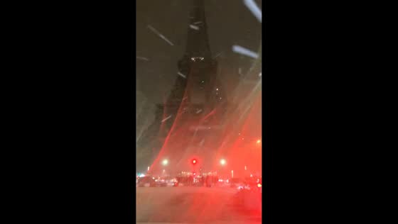 Snow flurries blanket the Eiffel Tower in Paris, France 