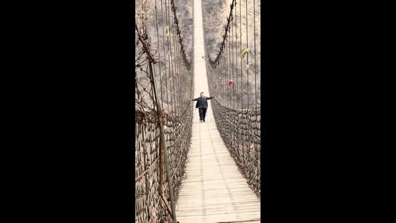 Monkey chases two men on suspension bridge during challenge in Henan, China