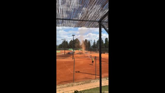 Man disperses dust devil with water hose in Samobor, Croatia