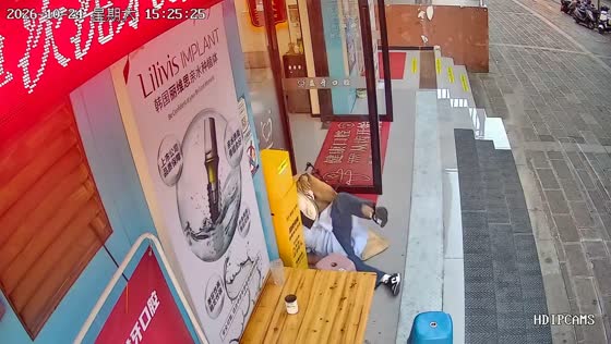 Folding chair collapses beneath woman outside a dental clinic in Guangdong, China
