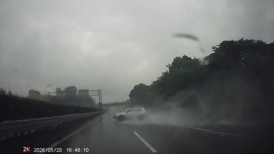 Car skids during heavy rain on highway nearly hits barrier in Jiangxi, China