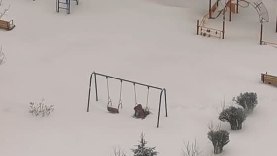 Persistent child swings through cyclone Vanya's snowy playground