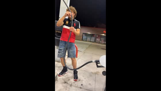Man loses balance while trying to move fuel hose at gas station in Michigan, USA