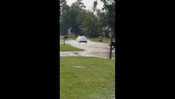 Cars drive through flooded streets after heavy rain in Houston, Texas, USA